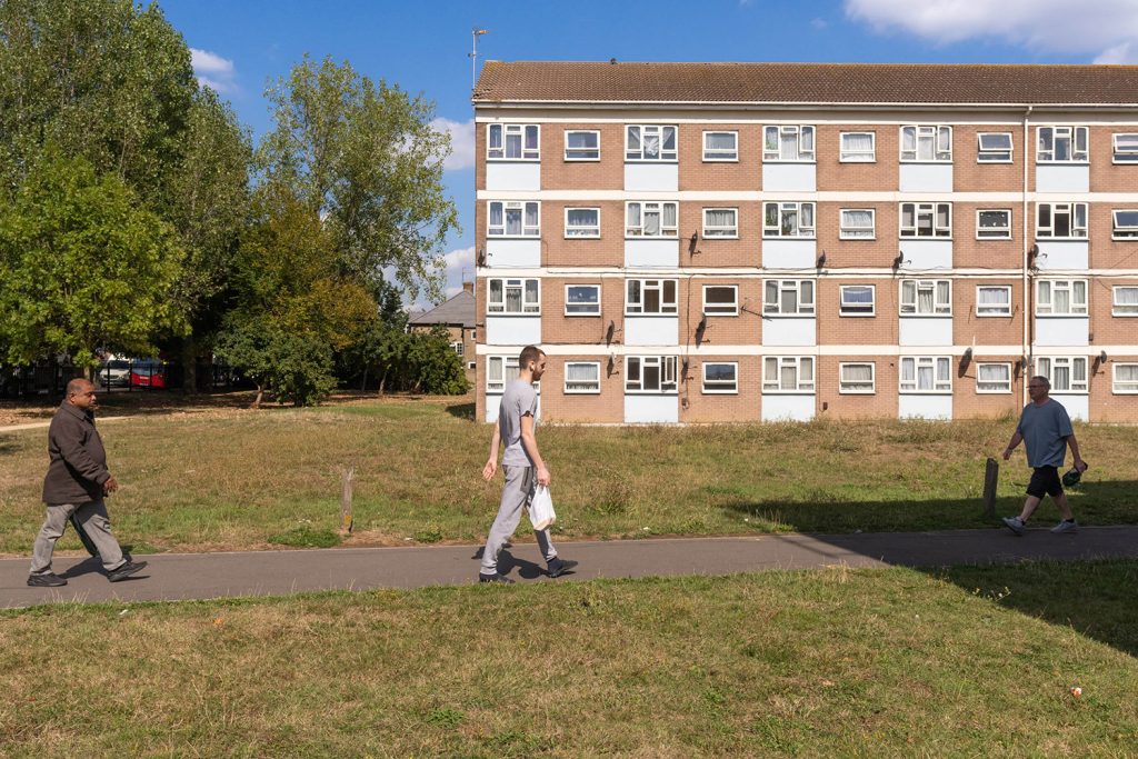 A group of people walking in front of a building.