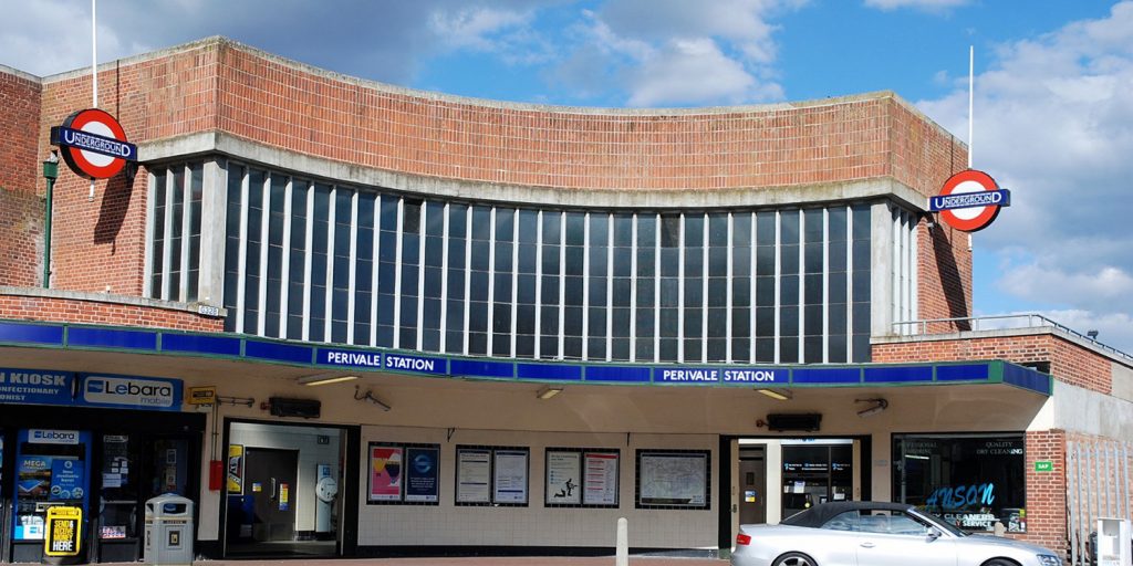 A car is parked in front of a train station.