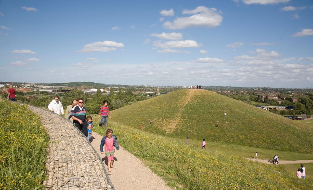 A group of people walking on a grassy hill.