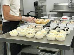 A man preparing cupcakes in a kitchen.