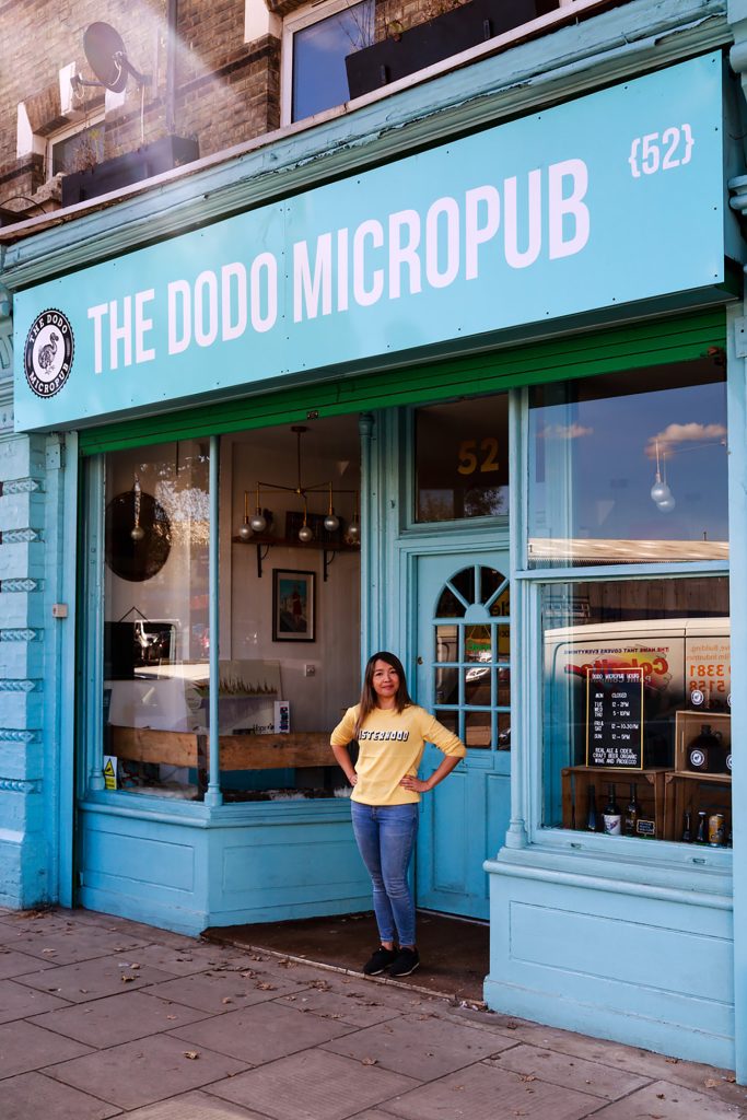 A woman standing in front of the doodle micropub.