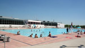 A large swimming pool with people swimming in it.