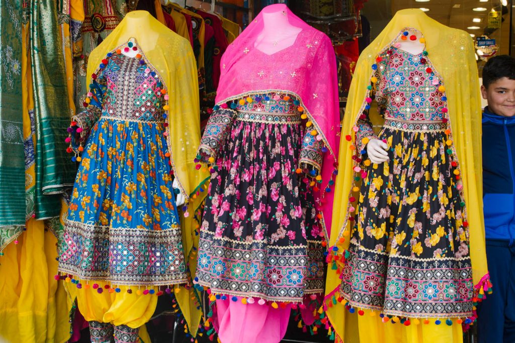 Mannequins with colorful dresses on display in a shop.