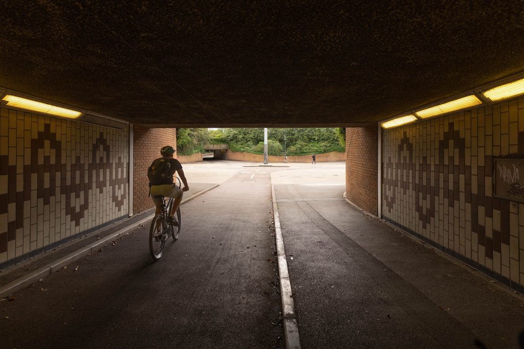 A person riding a bike through a tunnel.