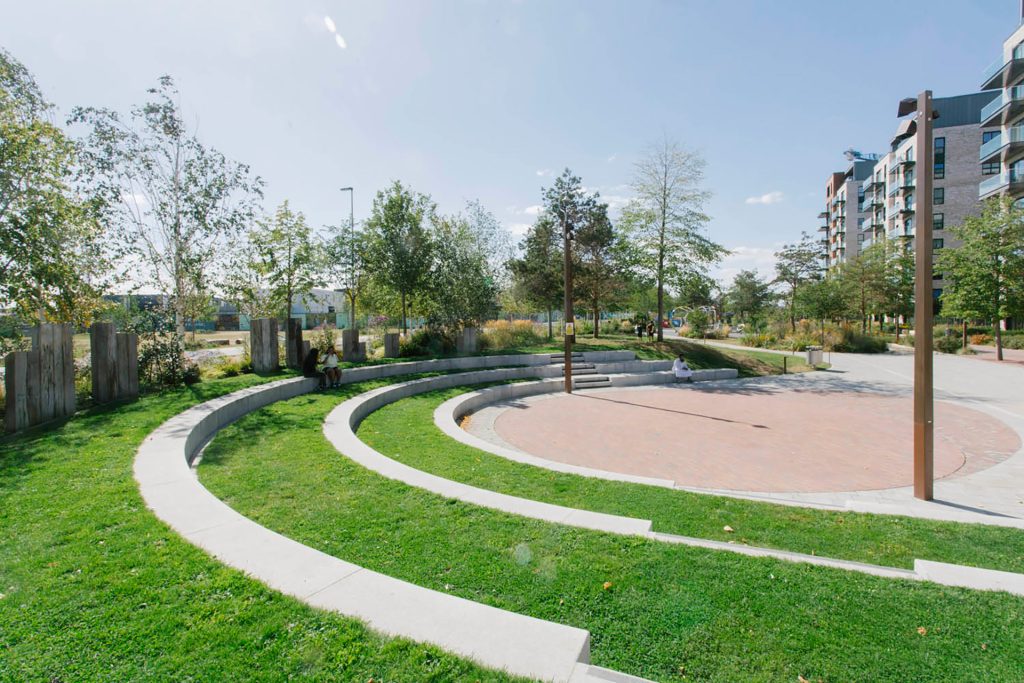A circular park with grass and a circular bench.