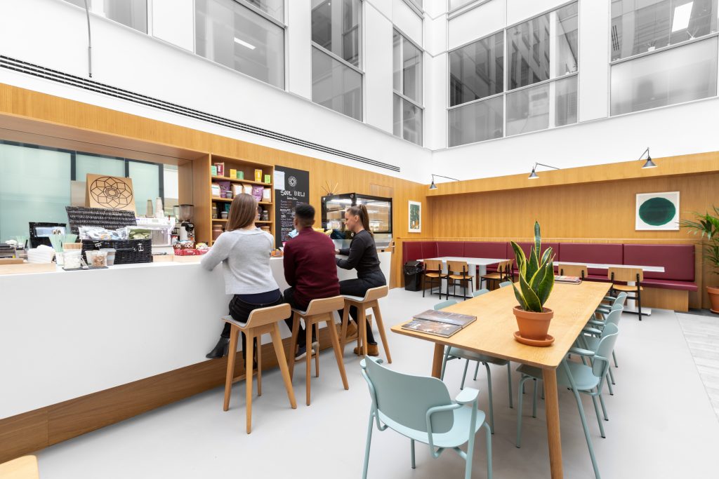 A group of people are sitting at a table in an office.